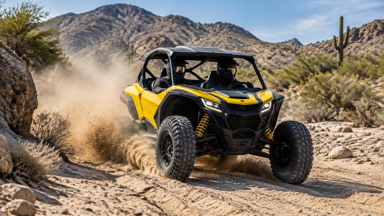 Yellow and black sport side-by-side kicking up sand in a desert wash with mountains behind
